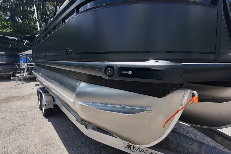 Slide: The Image of 2027 Viaggio V22S pontoon boat on trailer, sleek black design, parked outdoors. - 18
