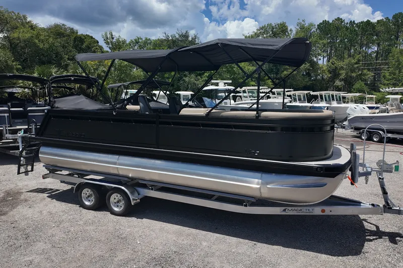 The Image of 2027 Viaggio V22S pontoon boat on trailer, parked outdoors with other boats. - 0