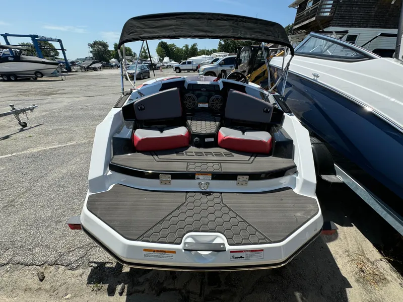 Slide: The Image of 2025 Scarab 165 ID boat with red seating and canopy in a marina. - 7
