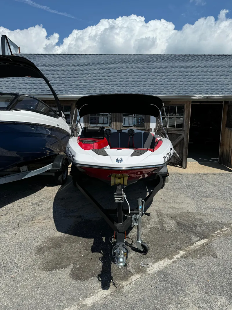 Slide: The Image of 2025 Scarab 165 ID boat parked outdoors under a clear sky. - 2
