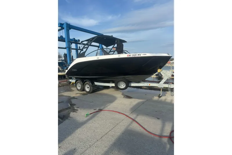 The Image of 2025 Yamaha Boats AR220 on trailer at marina, ready for launch. - 1