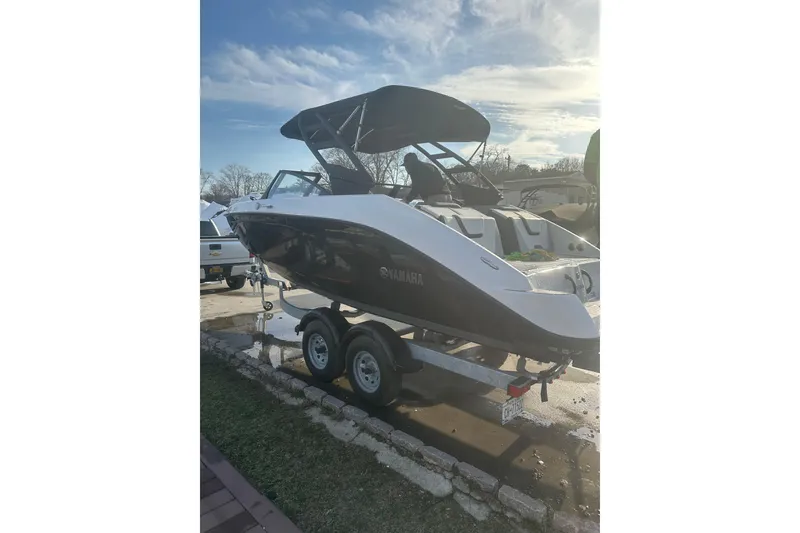 Slide: The Image of 2025 Yamaha Boats AR220 on trailer under clear sky, showcasing sleek design. - 2