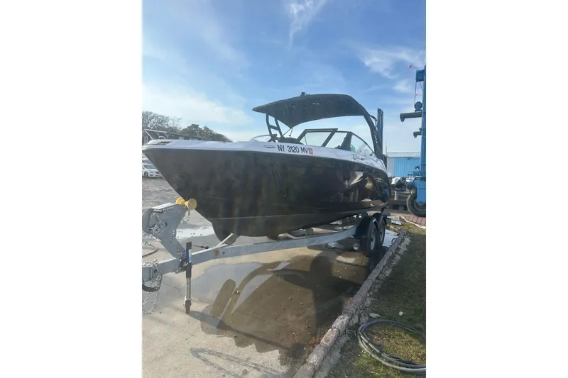 Slide: The Image of 2025 Yamaha Boats AR220 on trailer under clear blue sky. - 3