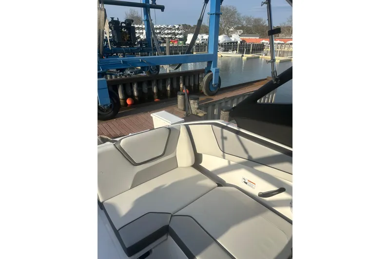 Slide: The Image of 2025 Yamaha Boats AR220 interior with dockside view and marina background. - 9
