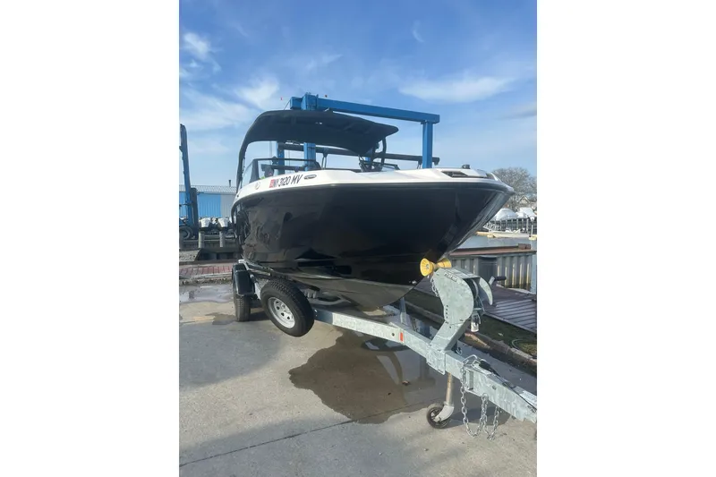 Slide: The Image of 2025 Yamaha Boats AR220 on trailer, ready for transport under a clear blue sky. - 4