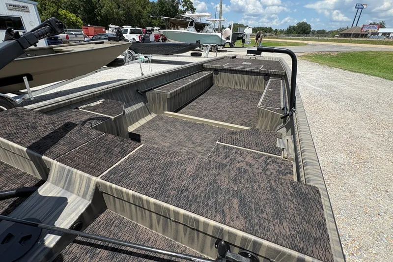 Slide: The Image of 2027 Gator Tail 1860 boat with spacious interior and camouflage design, parked outdoors. - 6