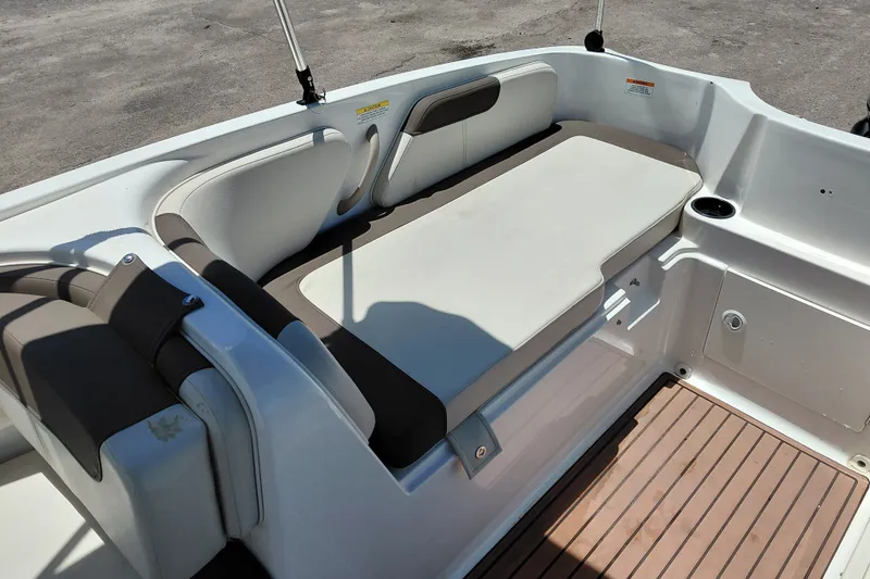 Slide: The Image of 2022 Bayliner Element E18 boat interior with cushioned seating and cup holder. - 23