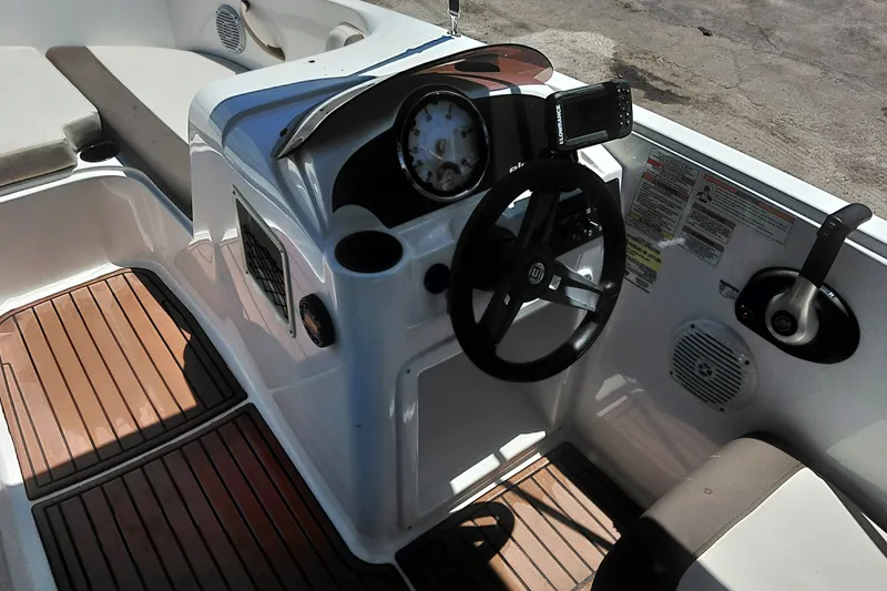 Slide: The Image of 2022 Bayliner Element E18 boat cockpit with steering wheel and control panel. - 18