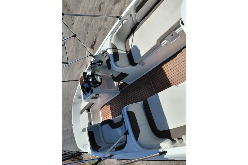 Slide: The Image of 2022 Bayliner Element E18 boat interior with seating and steering console. - 30