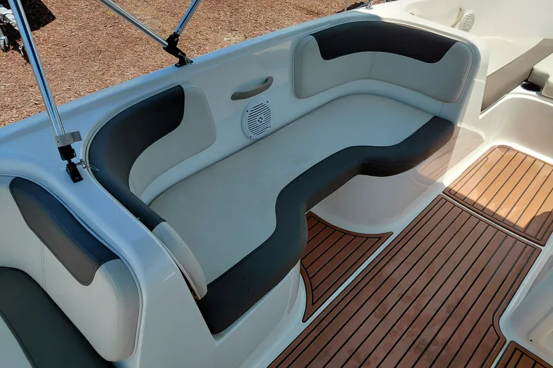 Slide: The Image of 2022 Bayliner Element E18 boat interior with cushioned seating and wood-style flooring. - 16