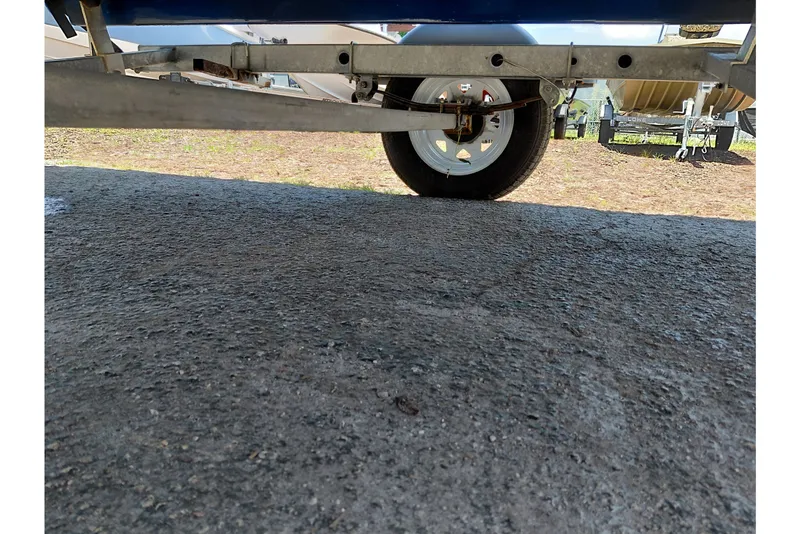 Slide: The Image of Trailer wheel of a 2022 Bayliner Element E18 boat on pavement. - 34