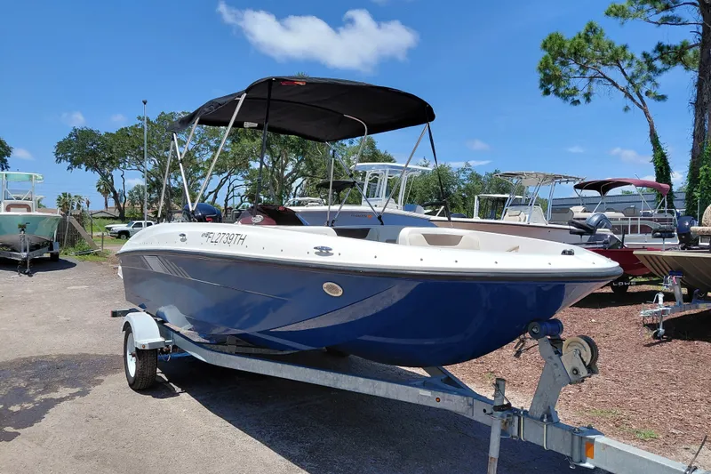 The Image of 2022 Bayliner Element E18 boat on trailer, parked outdoors under a clear blue sky. - 1