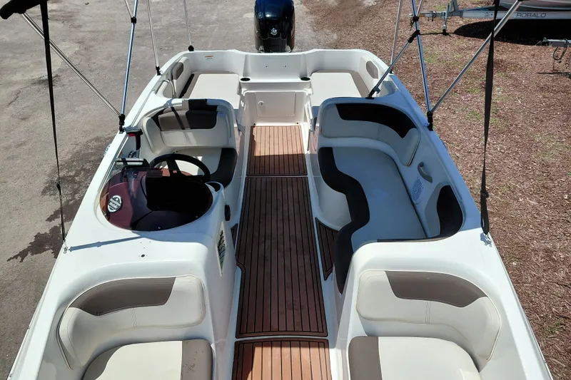 Slide: The Image of 2022 Bayliner Element E18 boat interior with spacious seating and wood-style flooring. - 14