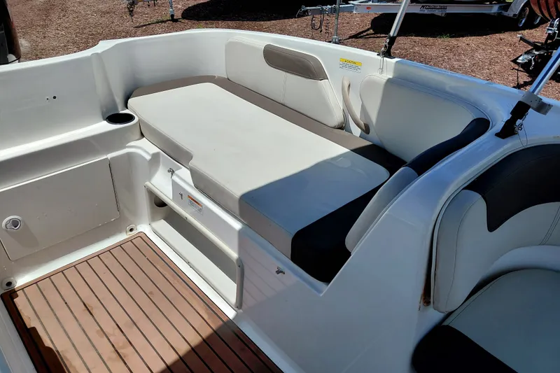 Slide: The Image of 2022 Bayliner Element E18 boat interior with cushioned seating and wood-style flooring. - 22