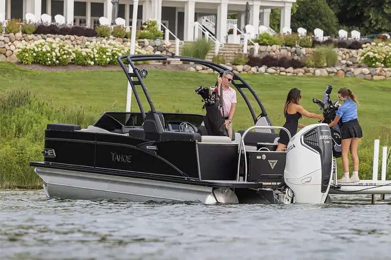 Slide: The Image of Manufacturer Provided Image: 2025 Tahoe Pontoon Cascade Quad Lounger on a scenic lake near a luxurious house. - 2