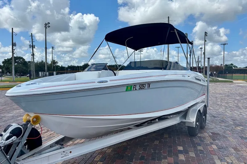 The Image of 2023 Tahoe 210 S Limited boat on trailer, parked outdoors under a cloudy sky. - 1