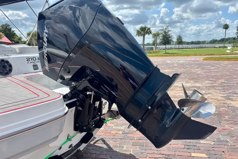 Slide: The Image of 2023 Tahoe 210 S Limited boat with Mercury outboard motor, parked on brick pavement. - 24