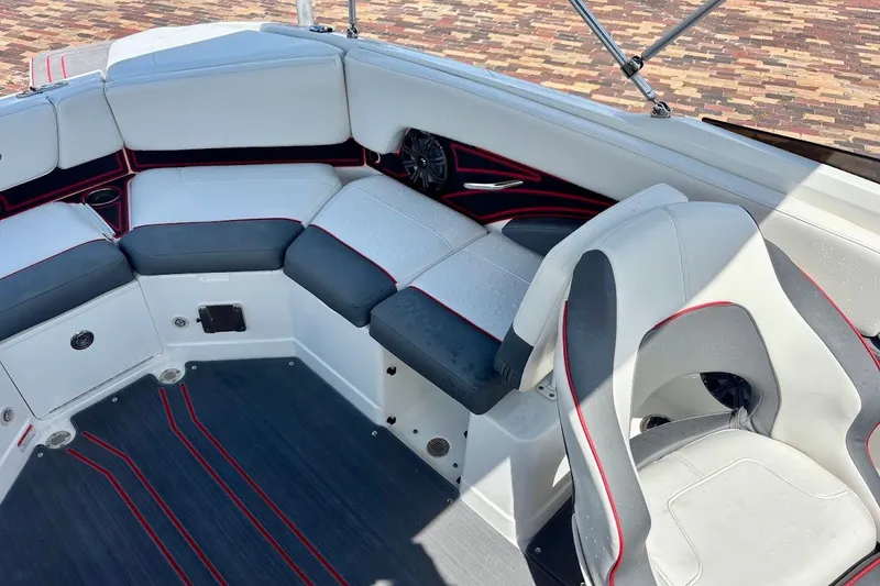 Slide: The Image of 2023 Tahoe 210 S Limited boat interior with white and gray seating, red accents. - 16