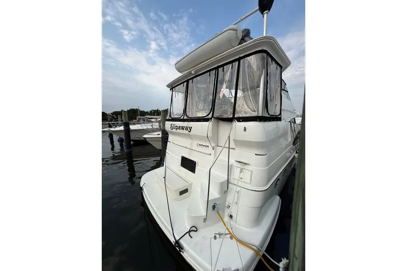 Slide: The Image of 2003 Carver 466 Motor Yacht docked, featuring a white exterior and enclosed deck area. - 6