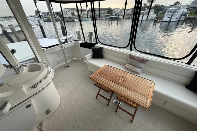 Slide: The Image of Interior of 2003 Carver 466 Motor Yacht with elegant seating and wooden table by waterfront. - 9
