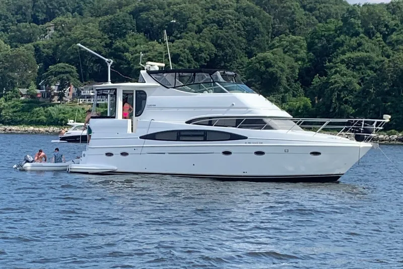 The Image of 2003 Carver 466 Motor Yacht on a scenic river with lush green shoreline. - 0