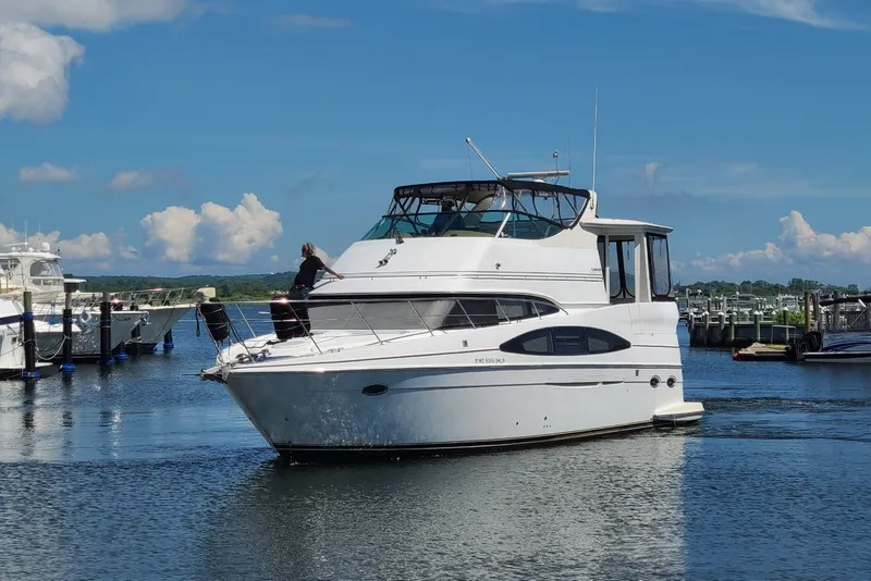 Slide: The Image of 2003 Carver 466 Motor Yacht cruising in a marina under a clear blue sky. - 2