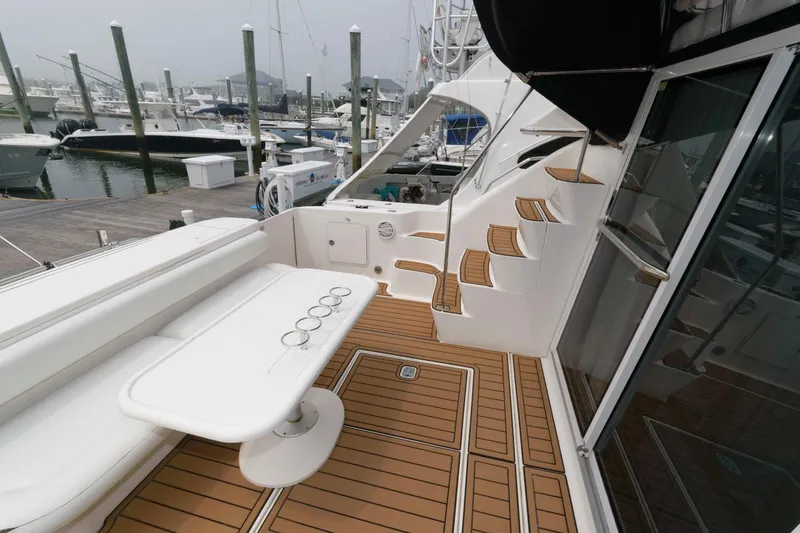 Slide: The Image of 2001 Sea Ray 450 Express Bridge yacht deck with seating and dock view. - 3