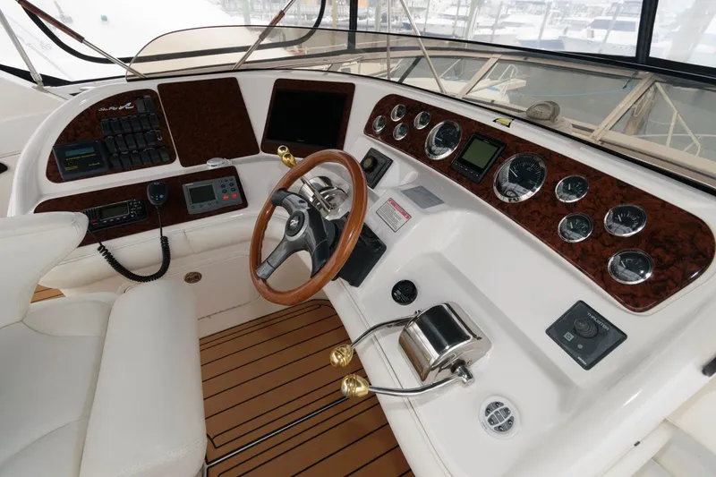 Slide: The Image of 2001 Sea Ray 450 Express Bridge helm with wood accents and modern controls. - 7