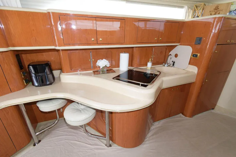 Slide: The Image of 2001 Sea Ray 450 Express Bridge yacht kitchen with wooden cabinets and modern appliances. - 15