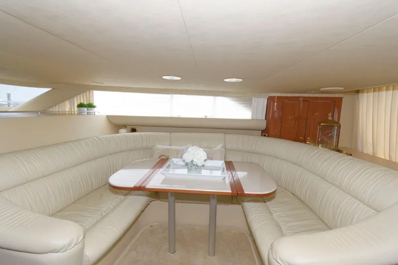 Slide: The Image of Luxurious interior of 2001 Sea Ray 450 Express Bridge yacht with plush seating and dining table. - 16