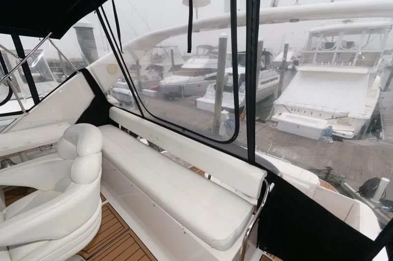 Slide: The Image of 2001 Sea Ray 450 Express Bridge interior with white seating and marina view. - 10