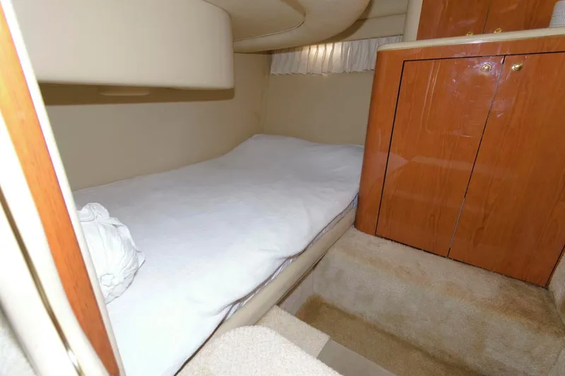 Slide: The Image of 2001 Sea Ray 450 Express Bridge cabin interior with bed and wooden cabinets - 21