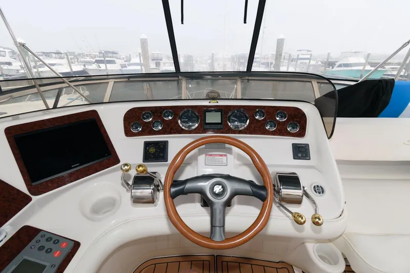 Slide: The Image of 2001 Sea Ray 450 Express Bridge helm with steering wheel and control panel. - 9
