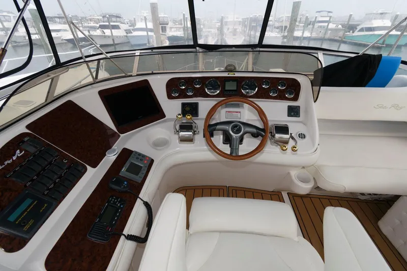 Slide: The Image of 2001 Sea Ray 450 Express Bridge helm with wood accents and modern controls. - 8