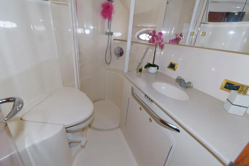 Slide: The Image of 2001 Sea Ray 450 Express Bridge bathroom with shower, sink, and toilet. - 19