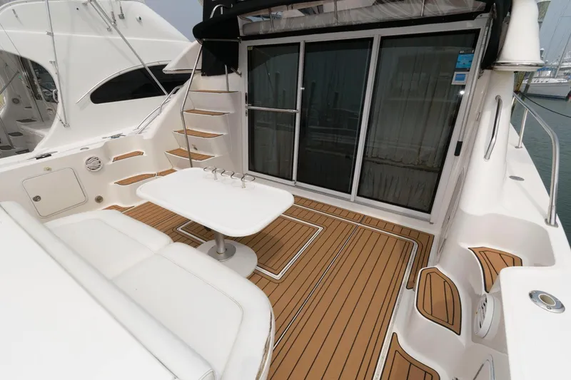 Slide: The Image of 2001 Sea Ray 450 Express Bridge yacht deck with seating and table. - 2