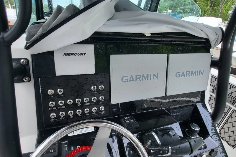 Slide: The Image of 2023 Wellcraft 302 Fisherman dashboard with Garmin displays and Mercury controls. - 12