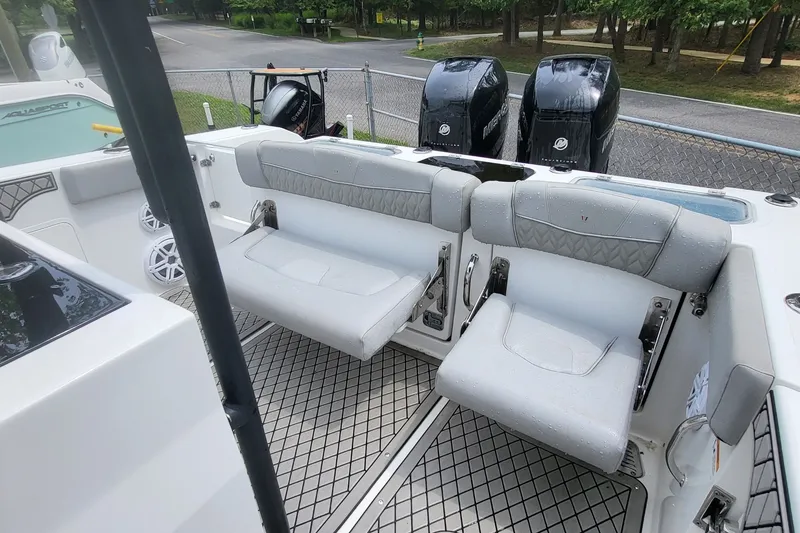 Slide: The Image of 2023 Wellcraft 302 Fisherman boat interior with cushioned seating and dual outboard motors. - 7