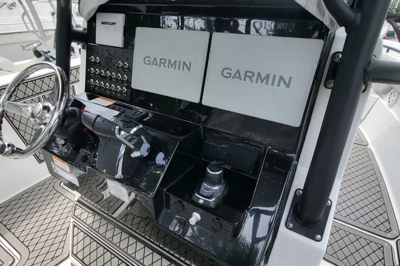 Slide: The Image of 2023 Wellcraft 302 Fisherman boat dashboard with Garmin navigation system and Mercury controls. - 14