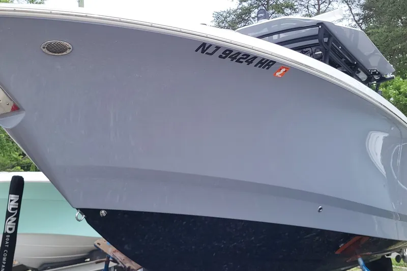 Slide: The Image of 2023 Wellcraft 302 Fisherman boat with registration NJ 9424 HR, docked outdoors. - 2