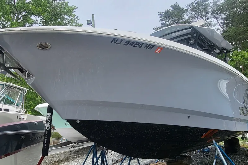 Slide: The Image of 2023 Wellcraft 302 Fisherman boat on stands, side view with registration number visible. - 3