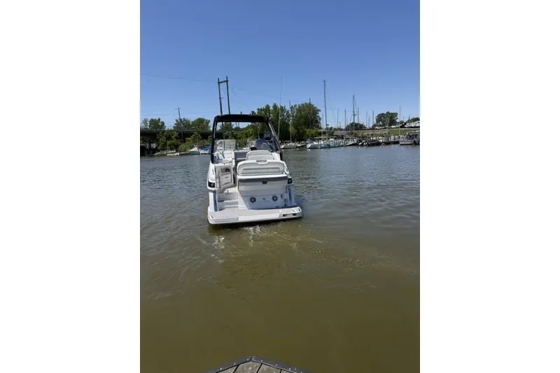 Slide: The Image of 2024 Regal 28 Express boat cruising on a calm river under clear blue skies. - 1
