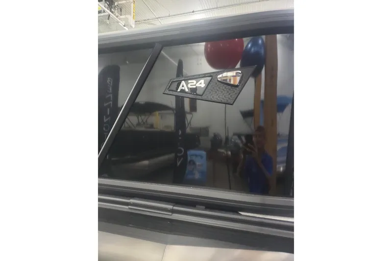 Slide: The Image of 2027 Alera A24Q vehicle window with model badge in showroom setting. - 3