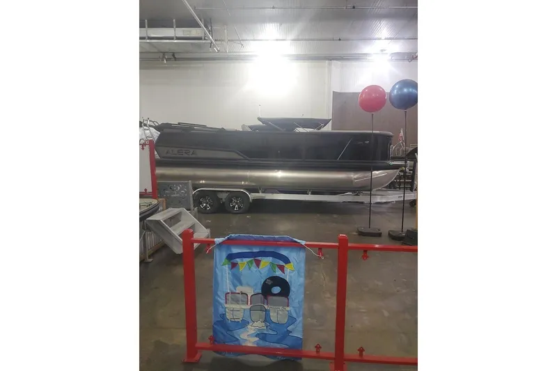 Slide: The Image of 2027 Alera A24Q boat displayed indoors with balloons and decorative banner. - 4