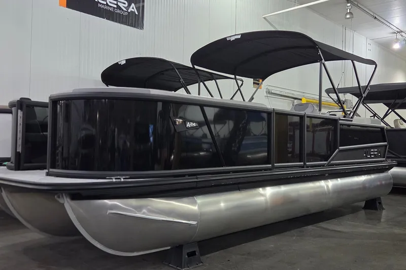The Image of Alera A24Q 2027 pontoon boat with sleek black design in a showroom setting. - 0