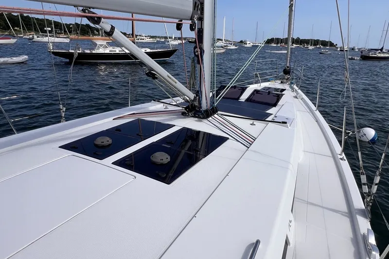 Slide: The Image of 2020 Hanse 458 yacht deck with sleek design, anchored in a scenic marina. - 16