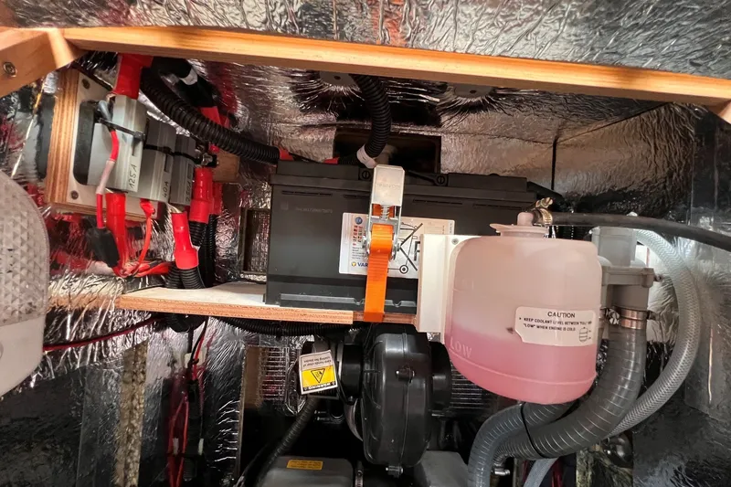 Slide: The Image of Engine compartment of a 2020 Hanse 458 yacht, featuring battery and coolant system. - 66