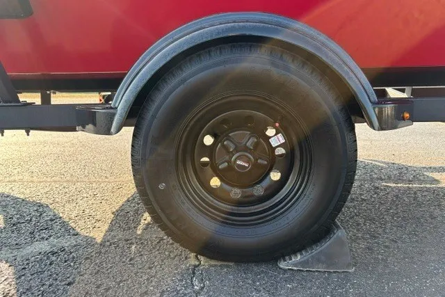 Slide: The Image of 2027 Tracker Bass Tracker Classic XL trailer wheel on asphalt with sunlight reflections. - 14