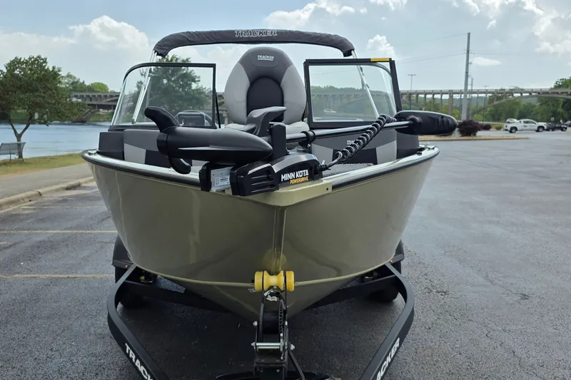 Slide: The Image of 2027 Tracker Pro Guide V-175 Combo boat on trailer, parked near a river. - 21