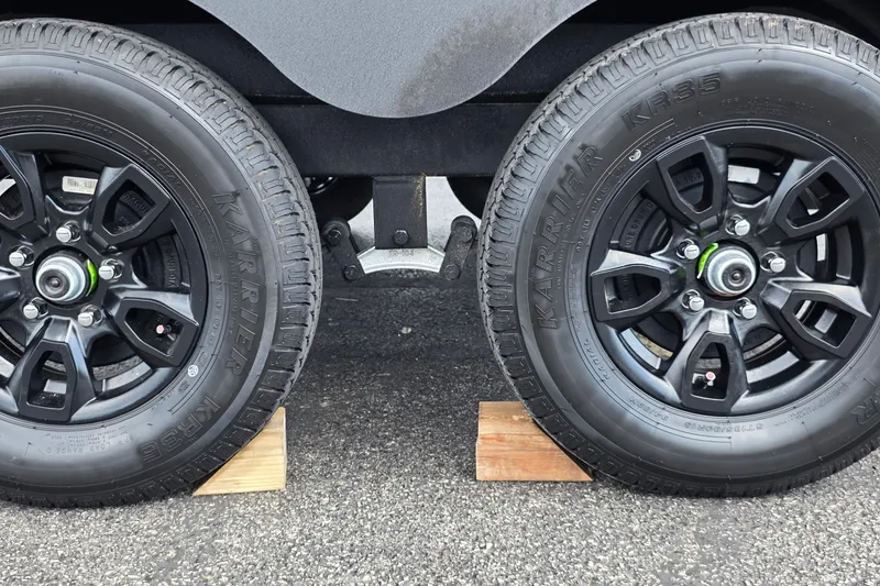 Slide: The Image of Dual black wheels of a 2027 Tracker Pro Guide V-175 Combo on wooden blocks. - 19